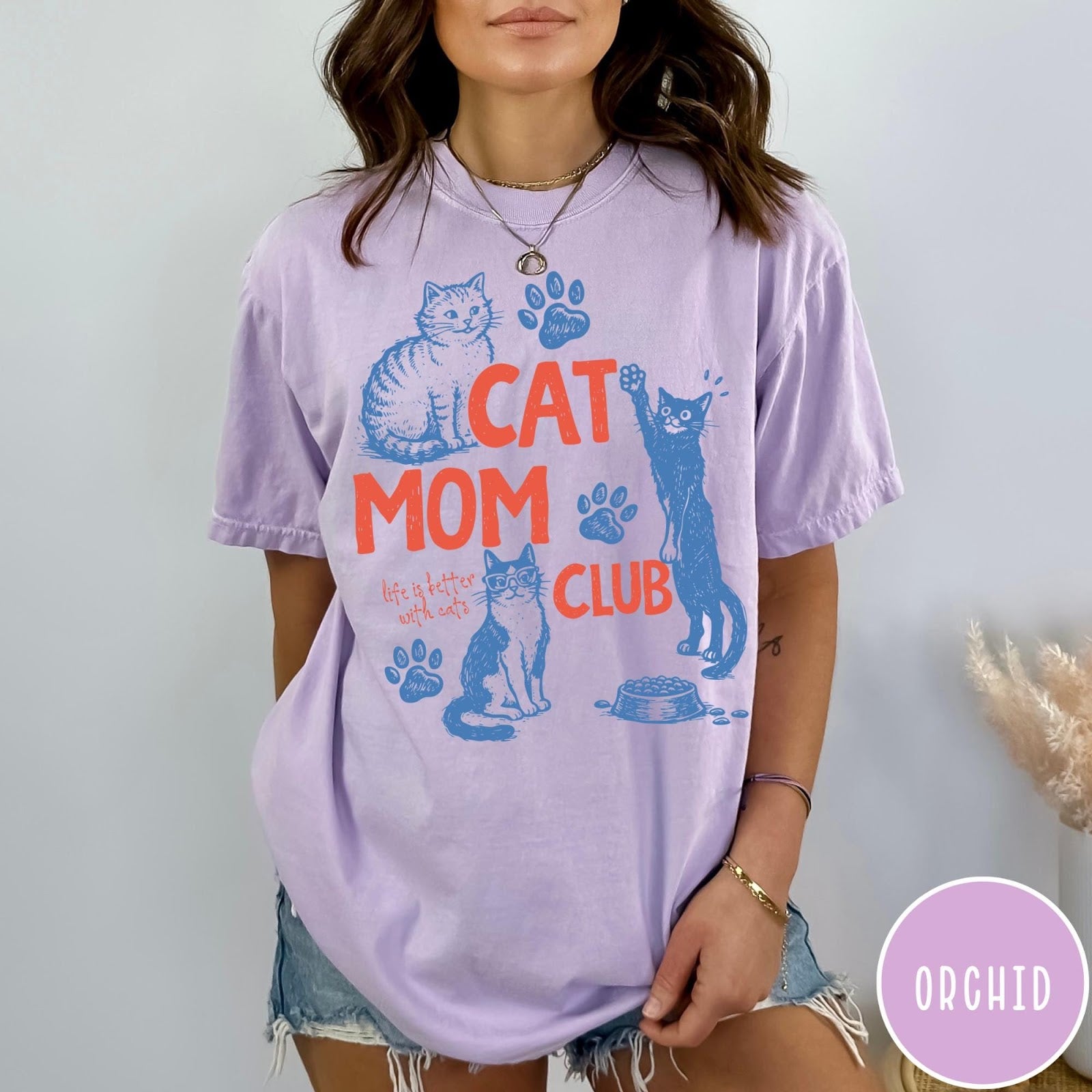 Comfort Colors tee in Orchid featuring graphic illustration of cats, paw prints, and Cat Mom Club text