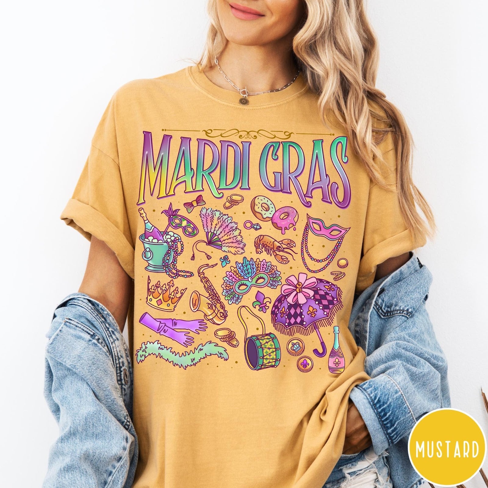 Comfort Colors tee in Mustard featuring vintage style Mardi Gras icons including a saxophone, mask, and umbrella.