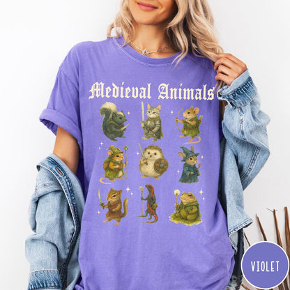 Comfort Colors tee in Violet featuring medieval animals graphic with fantasy characters including a cat, hedgehog, and frog