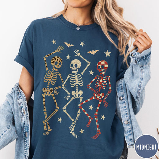 Comfort Colors tee in Midnight featuring dancing skeletons design with three skeletons, stars, and bats graphic