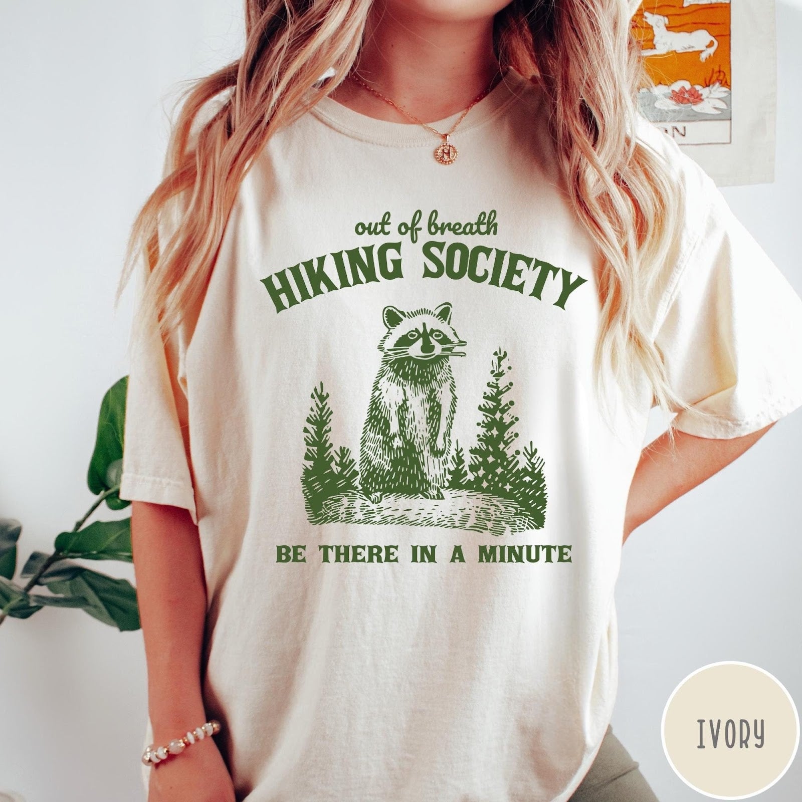 Comfort Colors tee in Ivory featuring outdoor style graphic of a raccoon standing in the forest