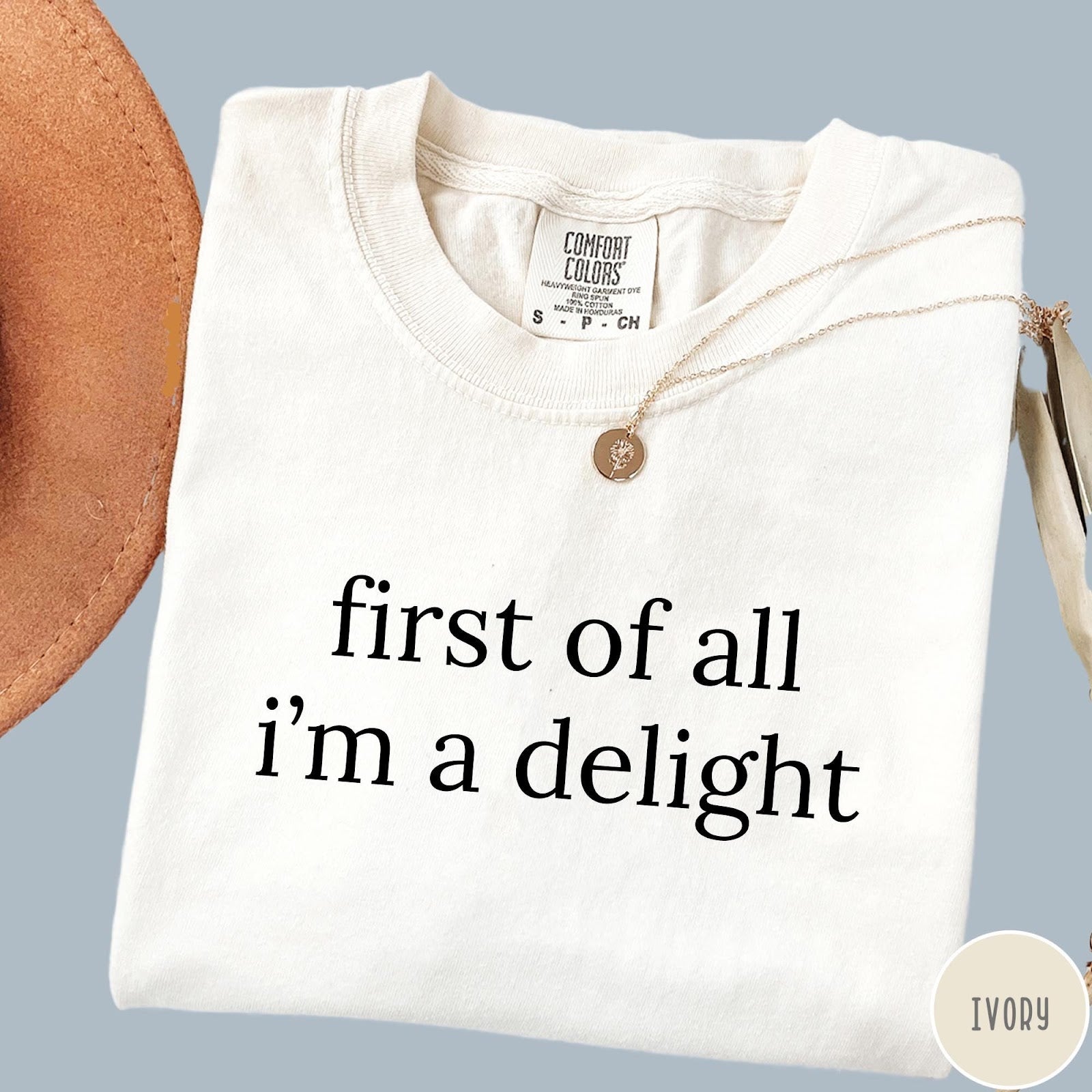 Comfort Colors tee in Ivory featuring typography graphic reading first of all i'm a delight in black