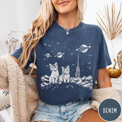 Comfort Colors tee in Denim featuring line art graphic of two kittens sitting on a planet with rocket