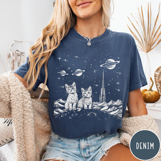 Comfort Colors tee in Denim featuring line art graphic of two kittens sitting on a planet with rocket