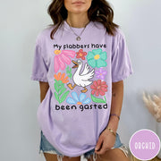 Comfort Colors tee in Orchid featuring playful cartoon style graphic of a goose surrounded by colorful flowers