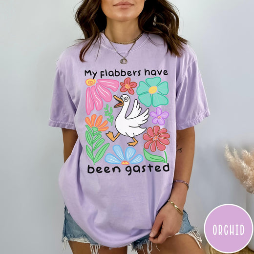 Comfort Colors tee in Orchid featuring playful cartoon style graphic of a goose surrounded by colorful flowers