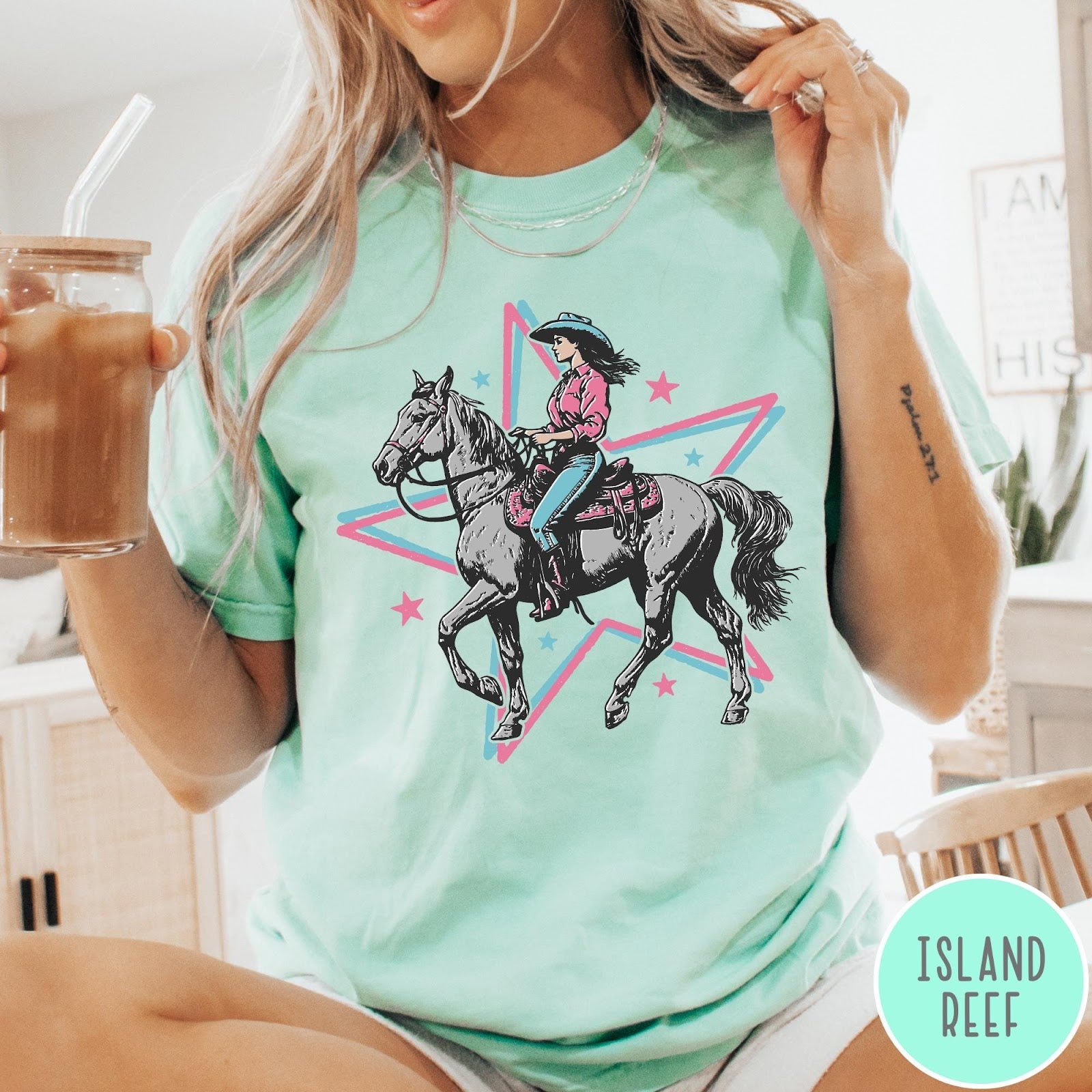 Comfort Colors tee in Island Reef featuring retro cowgirl graphic with a woman riding a horse inside a star