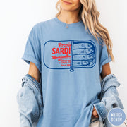 Comfort Colors tee in Washed Denim featuring vintage style sardine tin graphic with red text and blue fish
