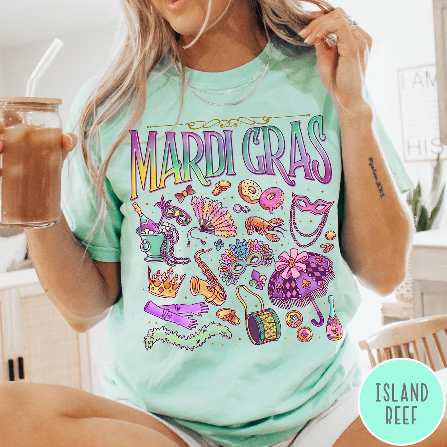 Comfort Colors tee in Island Reef featuring vintage style Mardi Gras icons including a saxophone, mask, and umbrella.