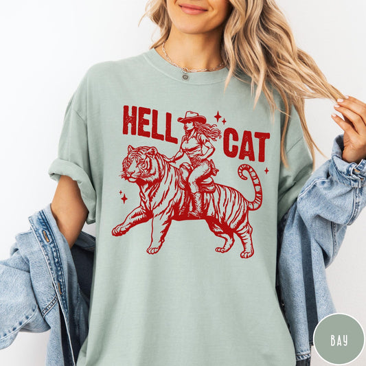 Comfort Colors tee in Bay featuring western style graphic of a cowgirl riding a tiger
