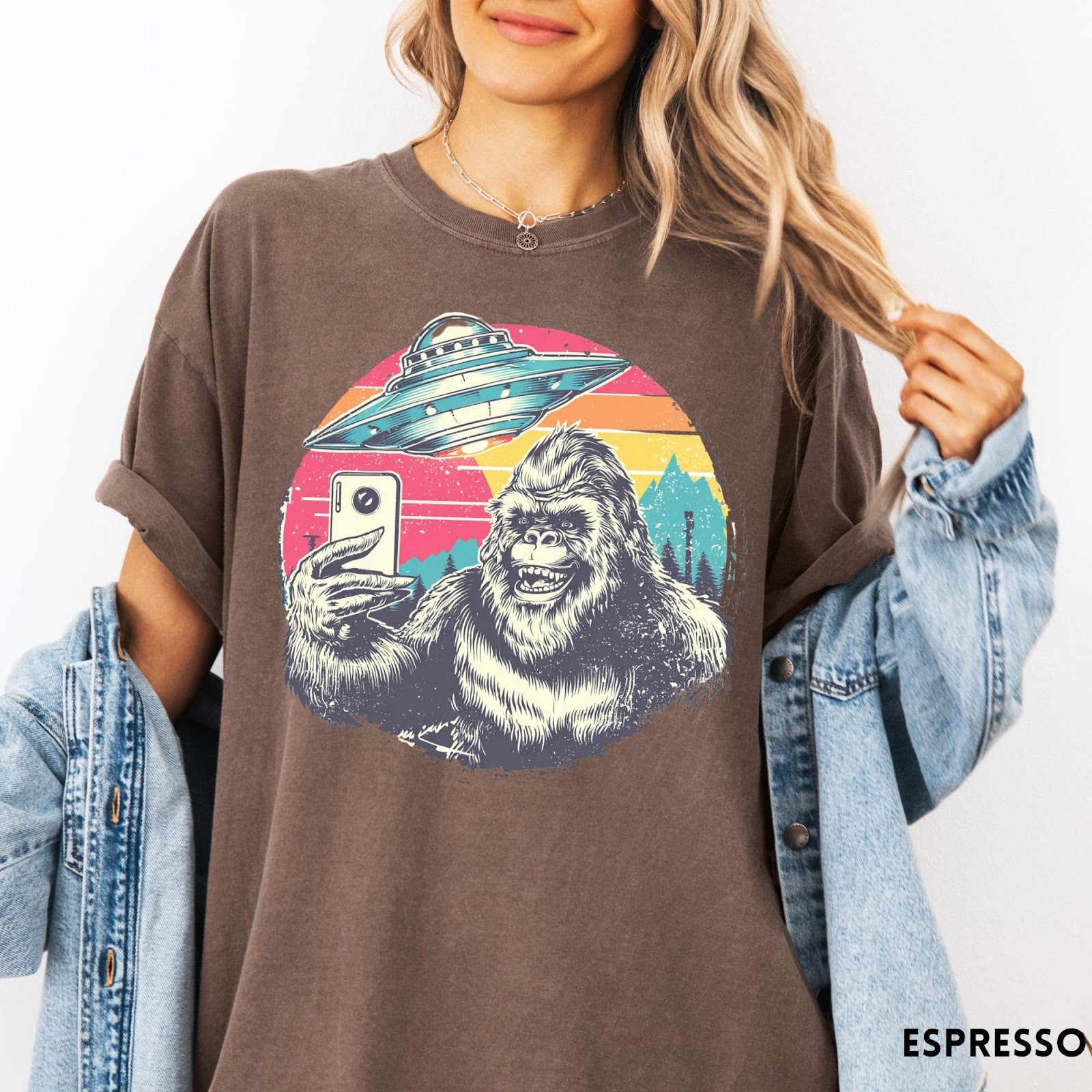 Comfort Colors tee in Espresso featuring retro graphic design of Bigfoot taking a selfie with a UFO