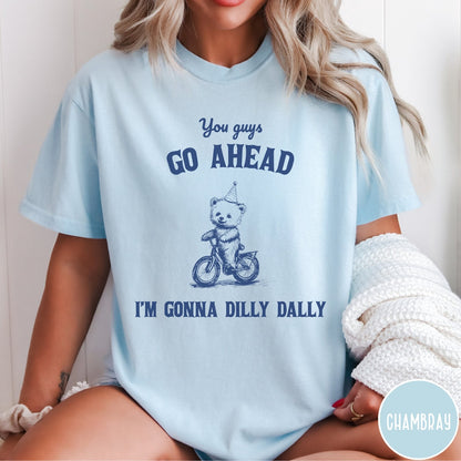 Comfort Colors tee in Chambray featuring illustration style graphic of a bear wearing a party hat riding bicycle