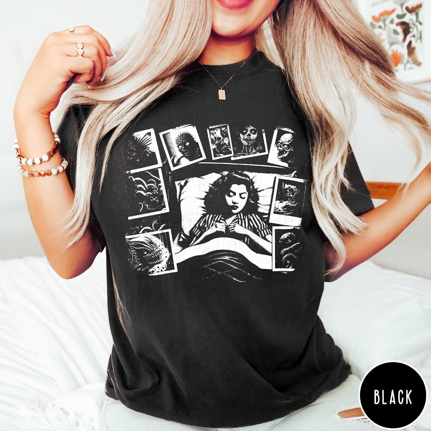 Comfort Colors tee in Black featuring graphic style illustration of a woman sleeping surrounded by horror polaroids