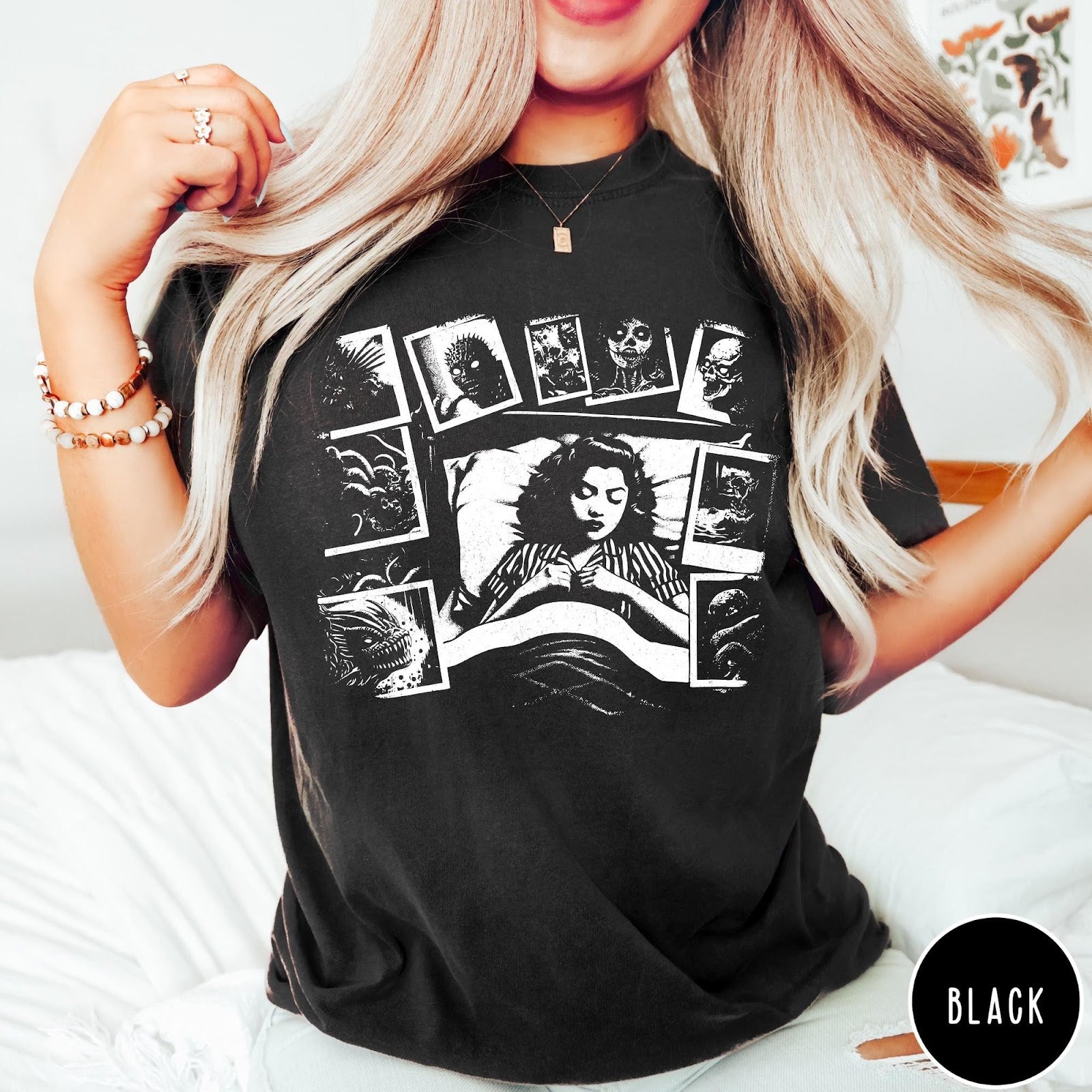 Comfort Colors tee in Black featuring graphic style illustration of a woman sleeping surrounded by horror polaroids