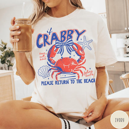 Comfort Colors tee in Ivory featuring beachy crab graphic with bow, starfish, seashell, and coastal text
