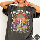 Comfort Colors tee in Pepper featuring retro style graphic with mushrooms, flowers, and sun with inspirational text