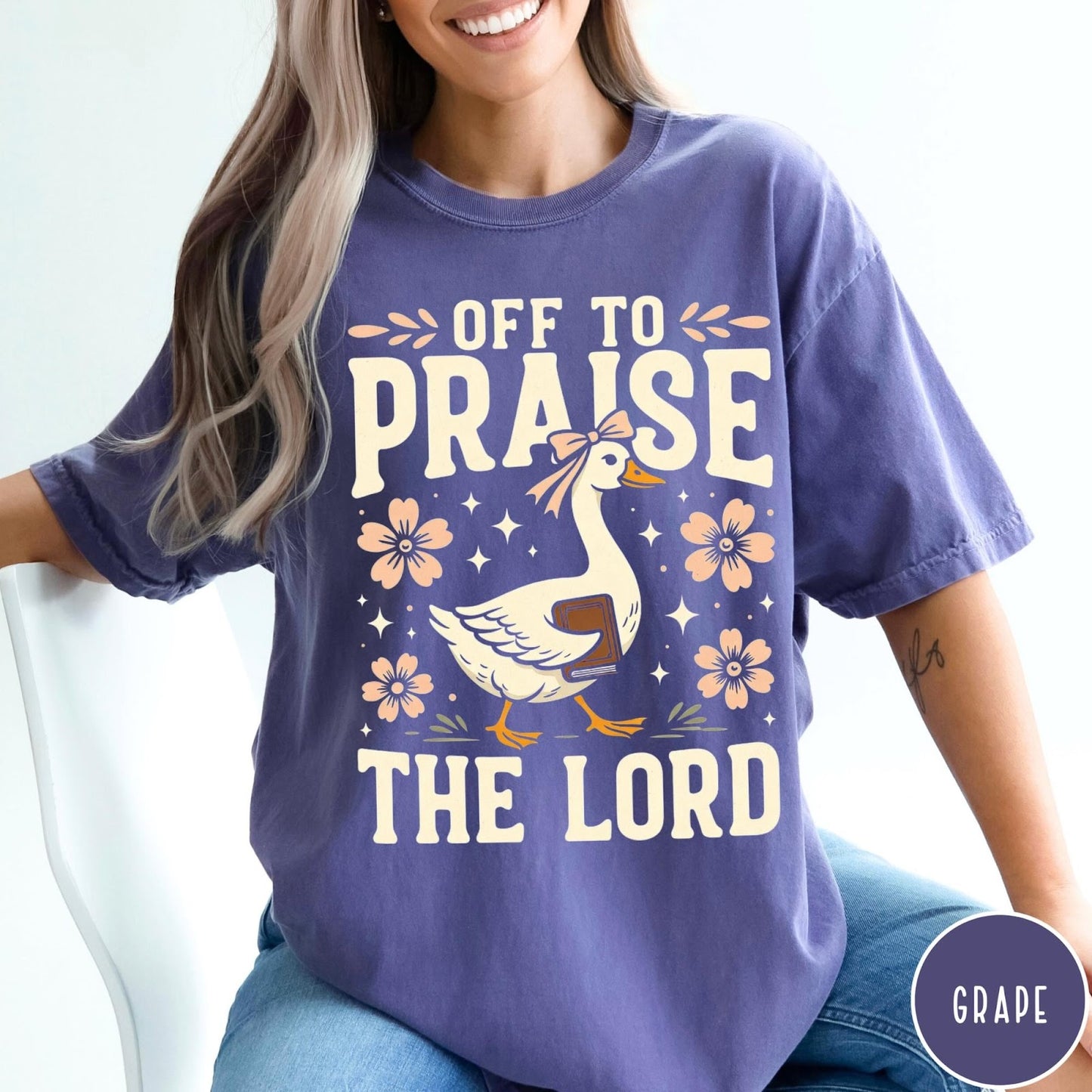 Comfort Colors tee in Grape featuring retro style graphic of a goose wearing a bow holding a book