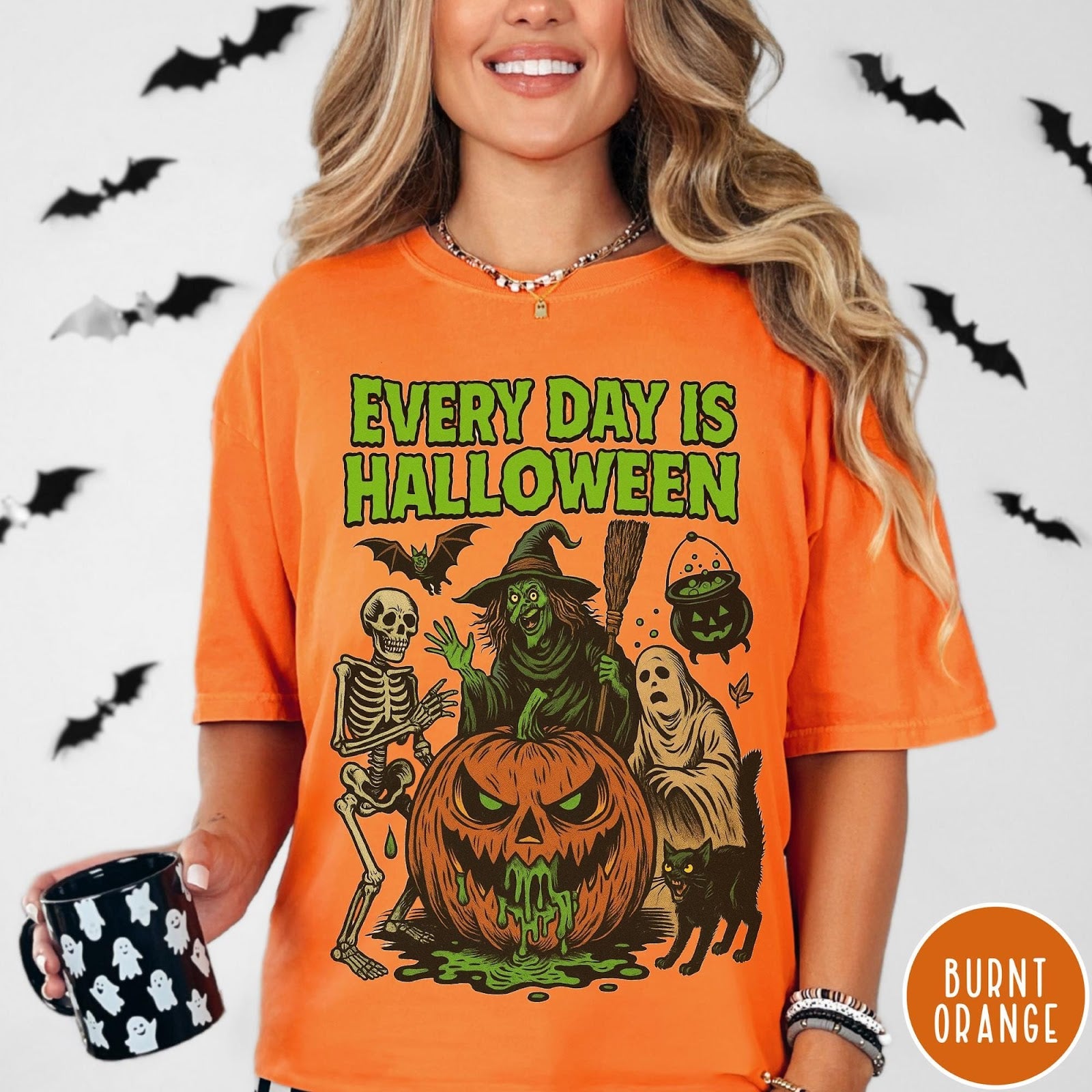 Comfort Colors tee in Burnt Orange featuring Halloween graphic with a witch, skeleton, ghost, and a dripping pumpkin.