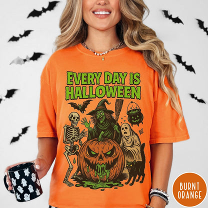 Comfort Colors tee in Burnt Orange featuring Halloween graphic with a witch, skeleton, ghost, and a dripping pumpkin.
