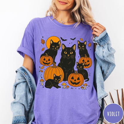 Comfort Colors tee in Violet featuring Halloween style graphic with black cats, pumpkins, bats, and fall leaves
