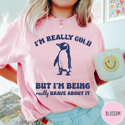 Comfort Colors tee in Blossom featuring penguin graphic with text I am really cold but I am brave