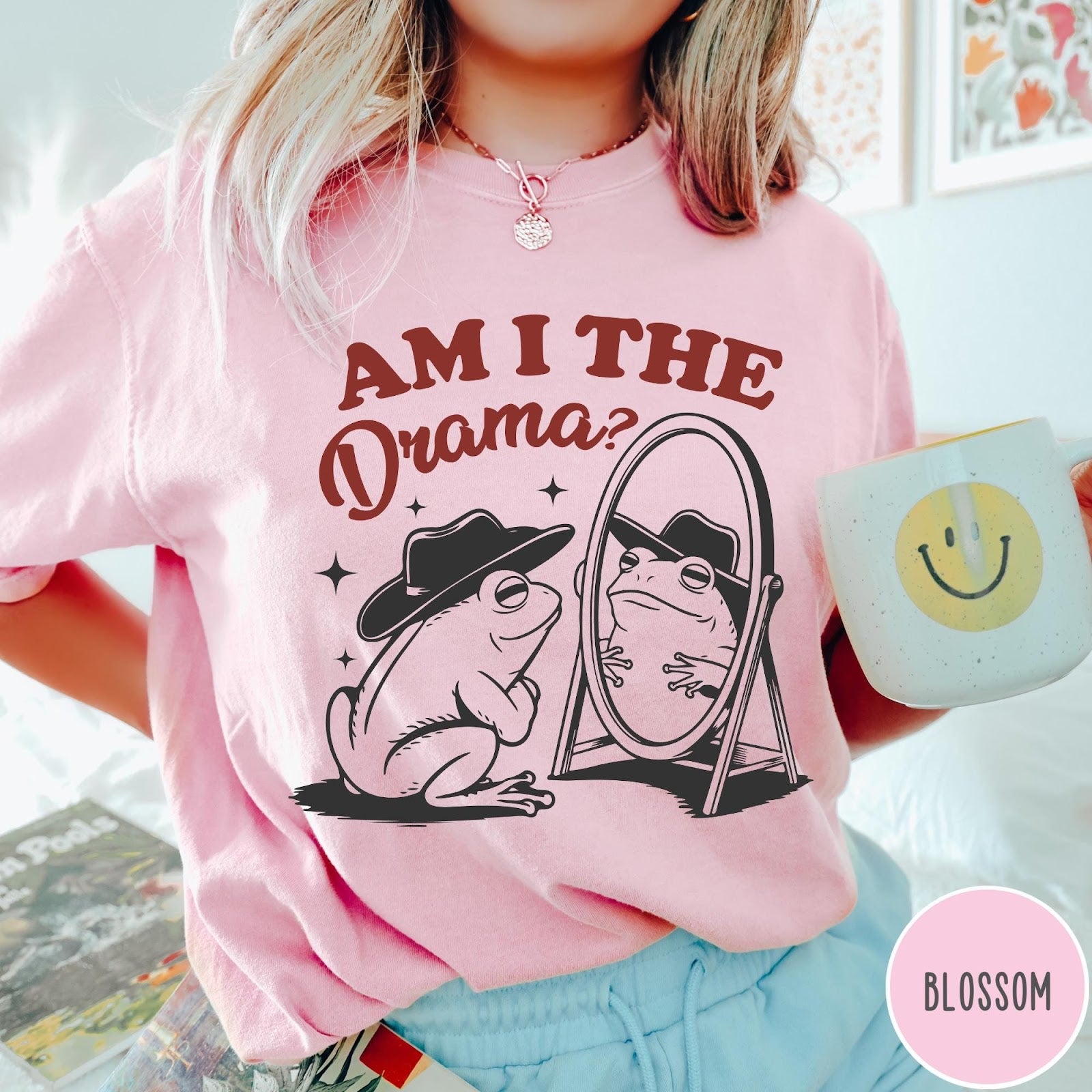 Comfort Colors tee in Blossom featuring whimsical frog graphic with a cowboy hat looking into a mirror