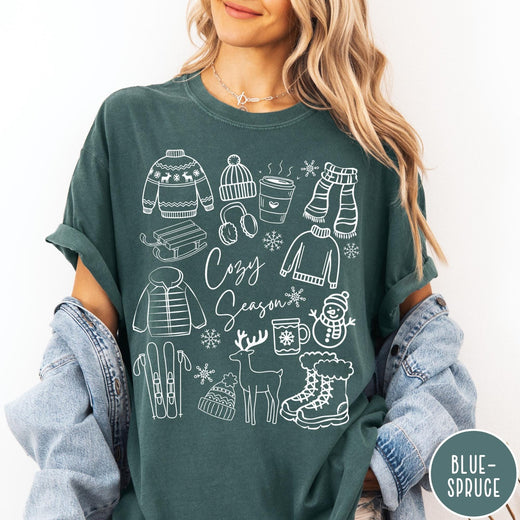 Comfort Colors tee in Blue Spruce featuring line art winter activities and seasonal items graphic design