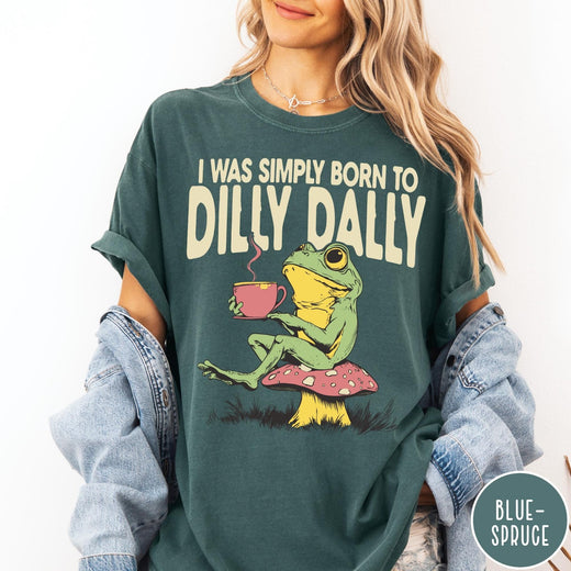 Comfort Colors tee in Blue Spruce featuring illustrative style graphic of a frog sitting on a mushroom drinking tea