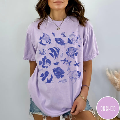 Comfort Colors tee in Orchid featuring coastal style graphic with various tropical fish and ocean life illustrations