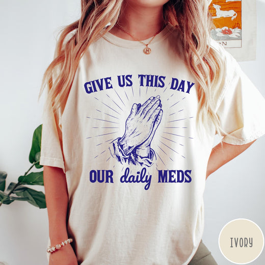 Comfort Colors tee in Ivory featuring graphic style praying hands with text Give Us This Day Our Daily Meds