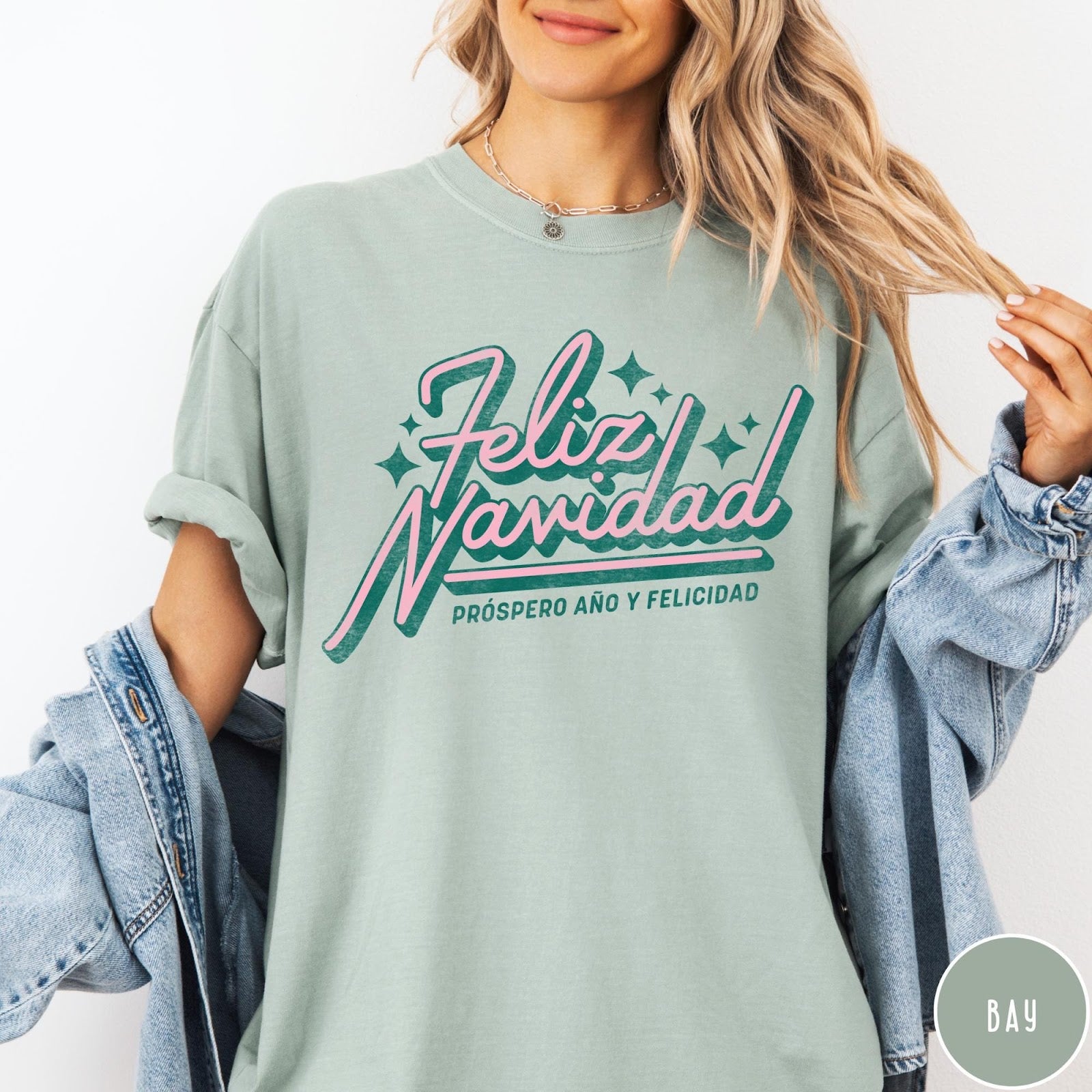 Comfort Colors tee in Bay featuring retro Christmas style Feliz Navidad greeting with stars and holiday text