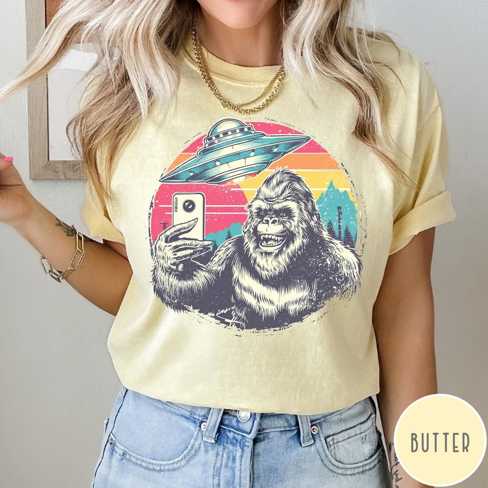 Comfort Colors tee in Butter featuring retro graphic design of Bigfoot taking a selfie with a UFO