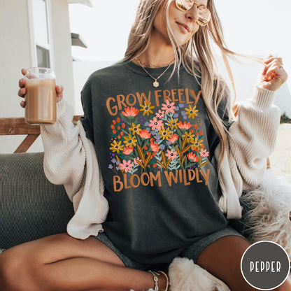 Comfort Colors tee in Pepper featuring wildflower design with text Grow Freely Bloom Wildly in earthy tones