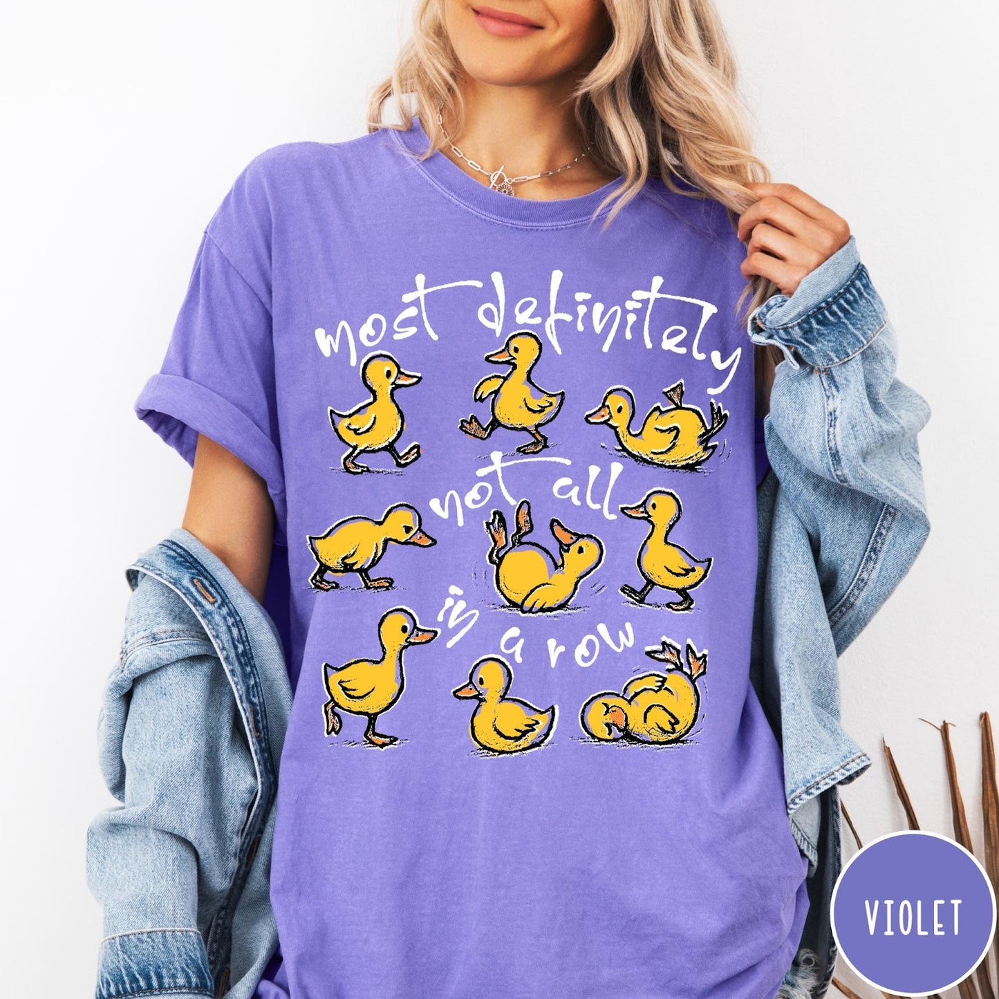 Comfort Colors tee in Violet featuring screen print style graphic of nine yellow ducks in various poses
