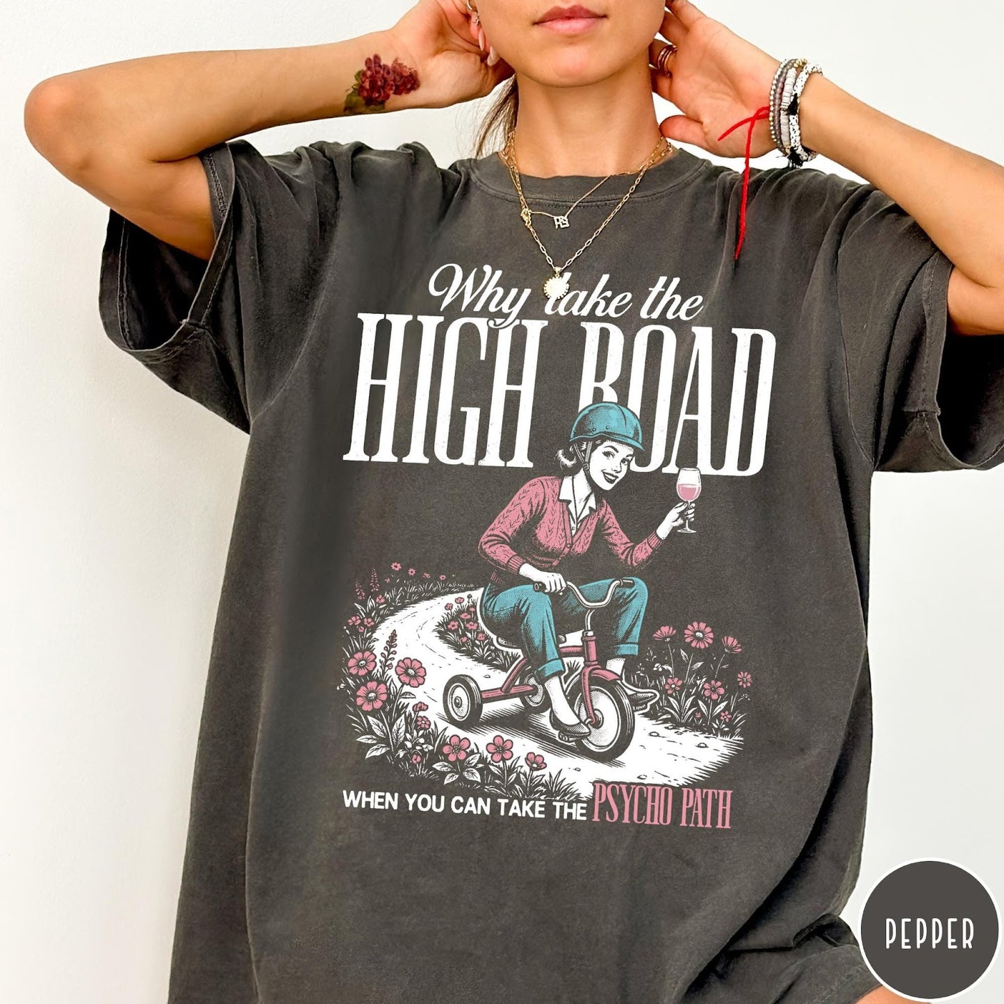 Comfort Colors tee in Pepper featuring vintage style graphic of a woman riding a tricycle with wine