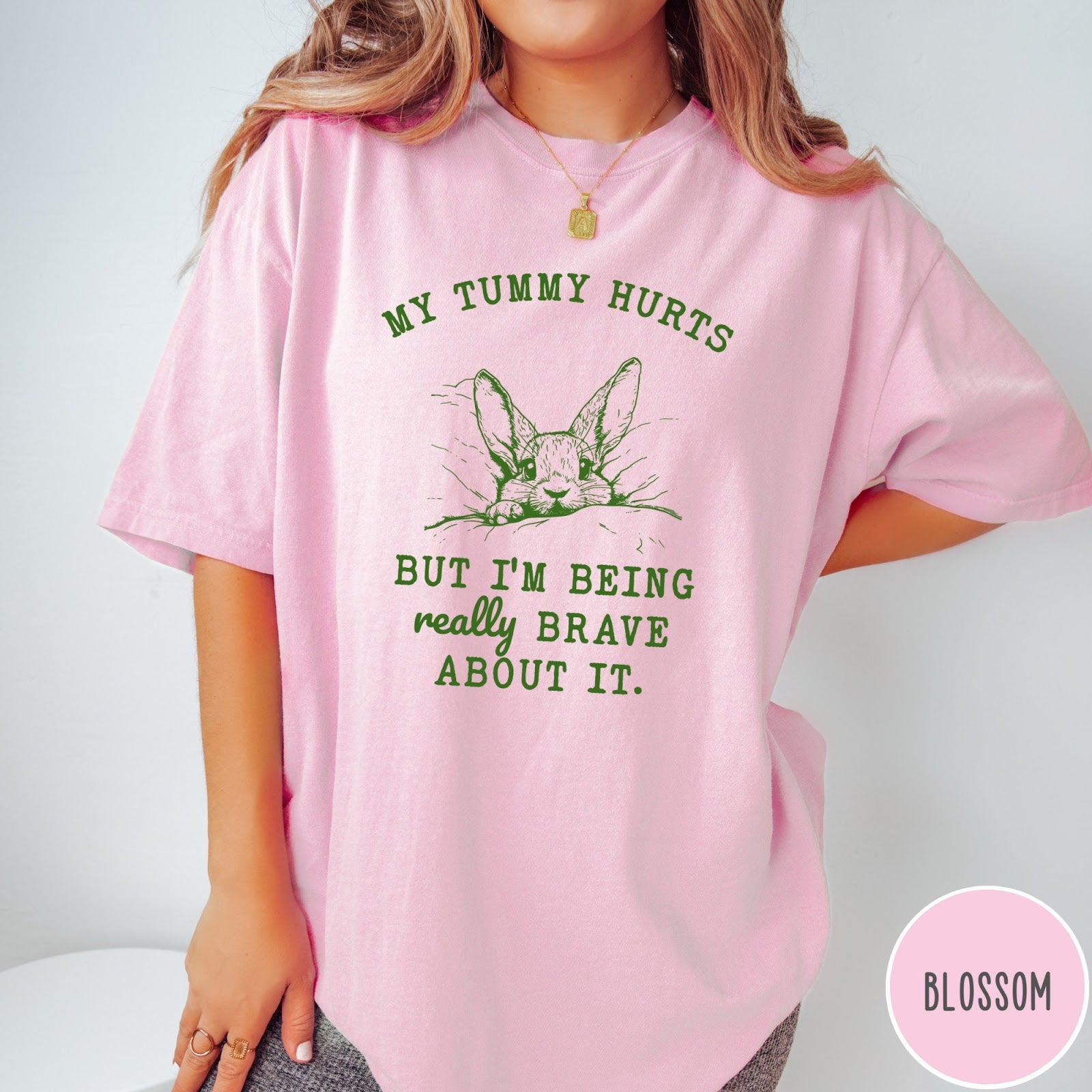 Comfort Colors tee in Blossom featuring line art graphic of a bunny with text My Tummy Hurts