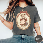 Comfort Colors tee in Pepper featuring vintage style teddy bear graphic inside a decorative lace oval frame