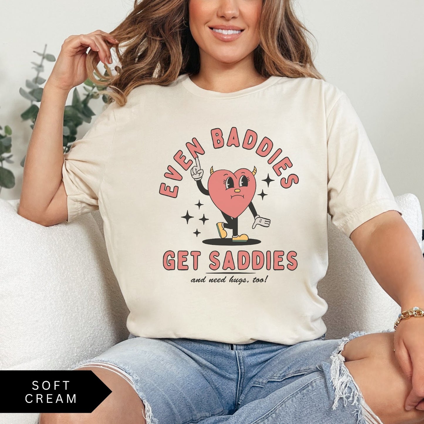 Comfort Colors tee in Soft Cream featuring retro style sad heart character with horns and text graphic