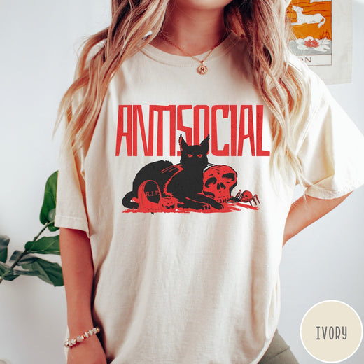 Comfort Colors tee in Ivory featuring retro graphic design of a black cat with skull and tombstone