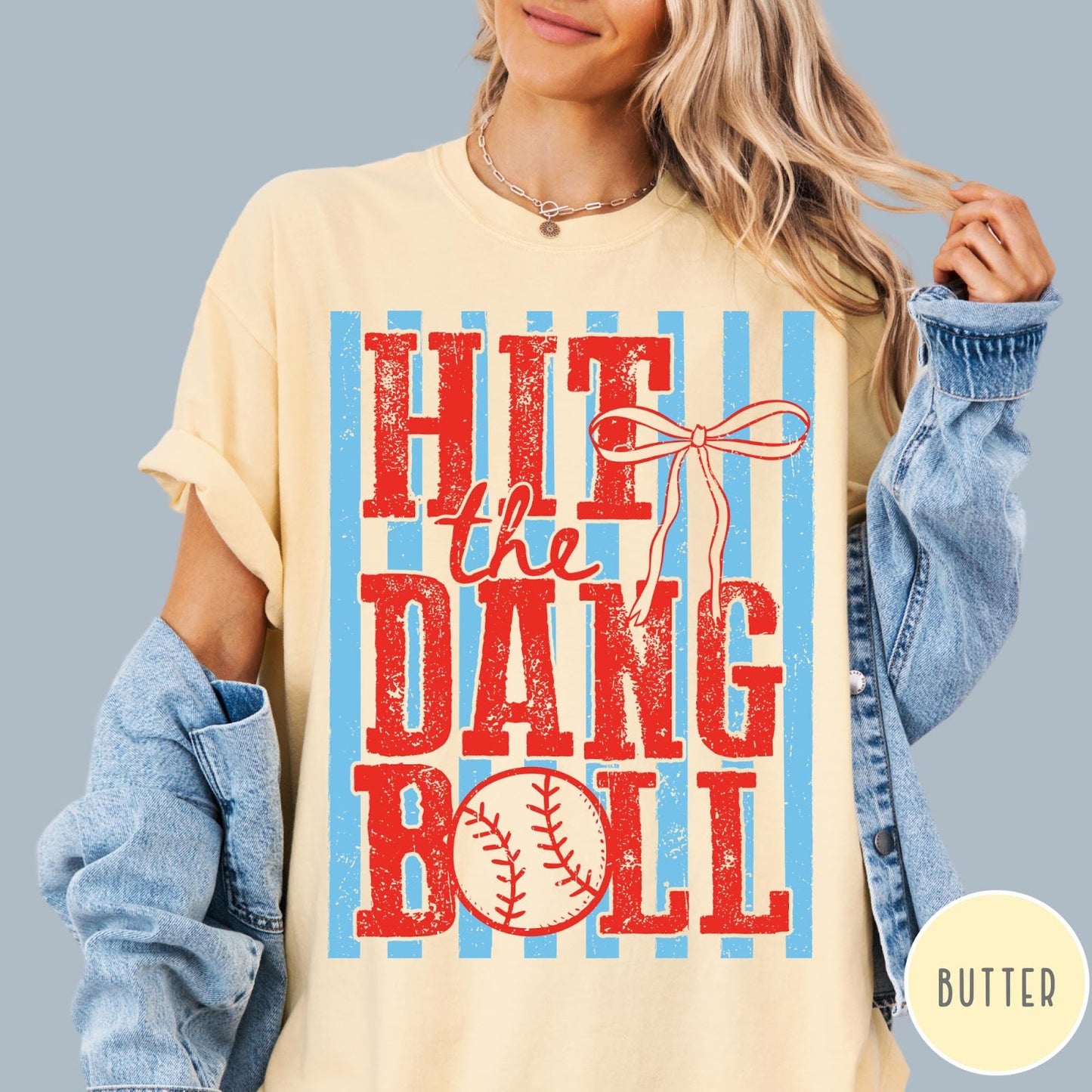 Comfort Colors tee in Butter featuring baseball design with red text and a blue striped background graphic