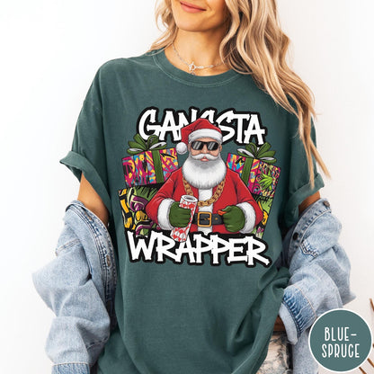 Comfort Colors tee in Blue Spruce featuring cartoon style Santa Claus wearing sunglasses and gold chain holding wrapping paper