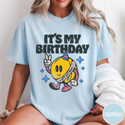 Comfort Colors tee in Chambray featuring retro birthday mascot graphic with peace sign and party hat