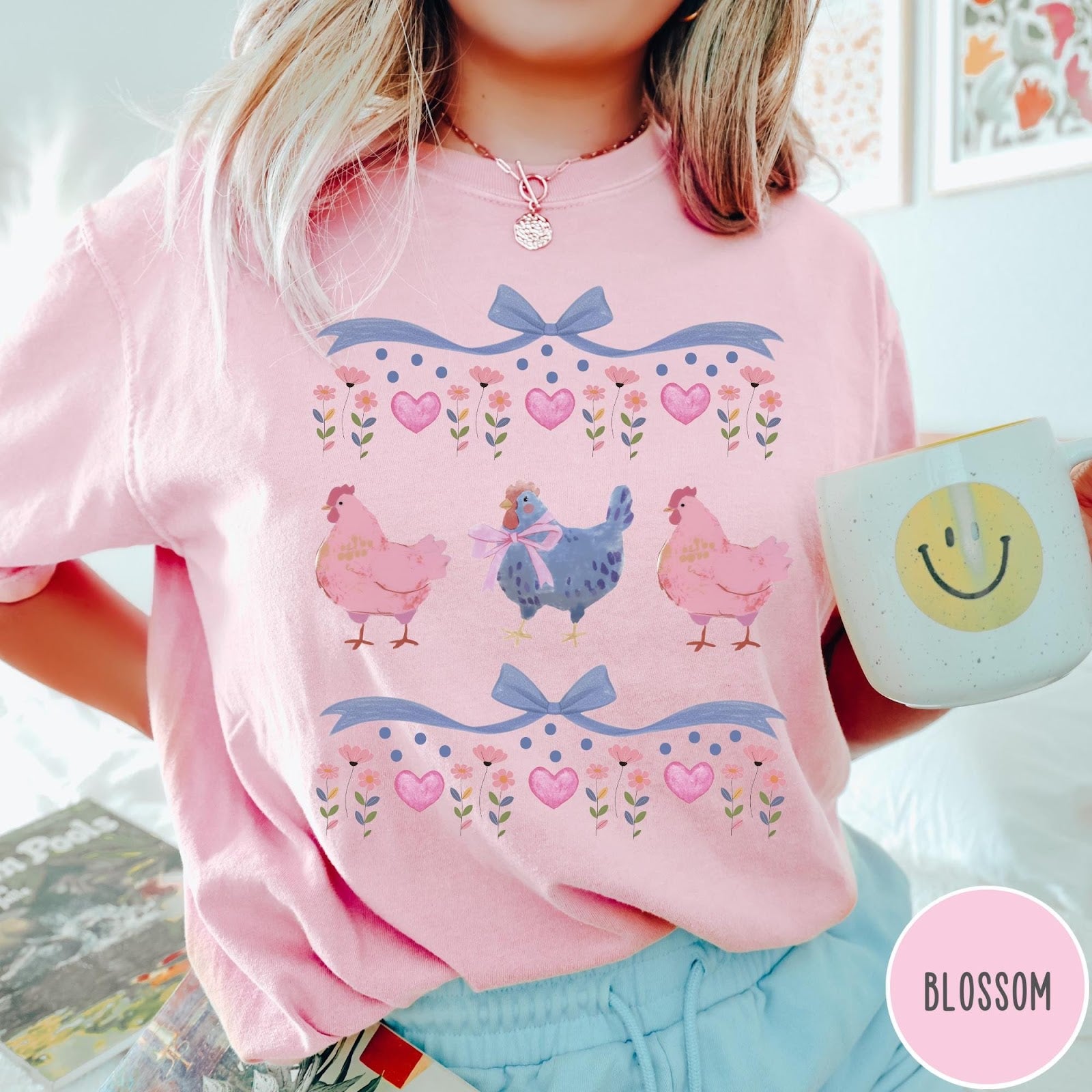 Comfort Colors tee in Blossom featuring vintage style graphic with three chickens, floral accents, and blue bows