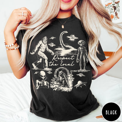 Comfort Colors tee in Black featuring vintage style cryptid graphic with Bigfoot, UFOs, and alien creatures.