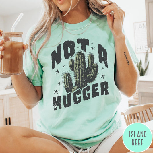 Comfort Colors tee in Island Reef featuring cactus graphic and Not a Hugger text with small stars