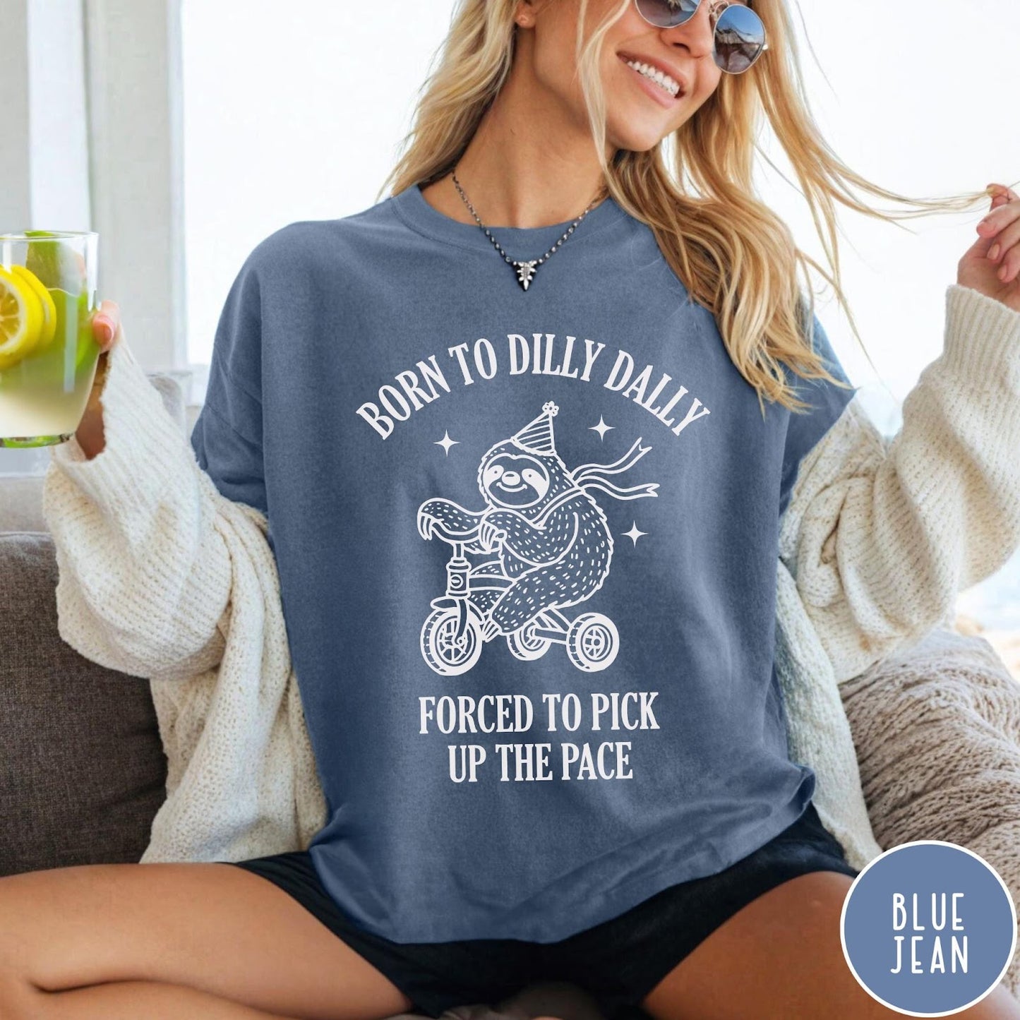 Comfort Colors tee in Blue Jean featuring cute sloth on a tricycle graphic with Born to Dilly Dally text