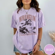 Comfort Colors tee in Orchid featuring western style graphic of a cowboy on horseback jumping a canyon