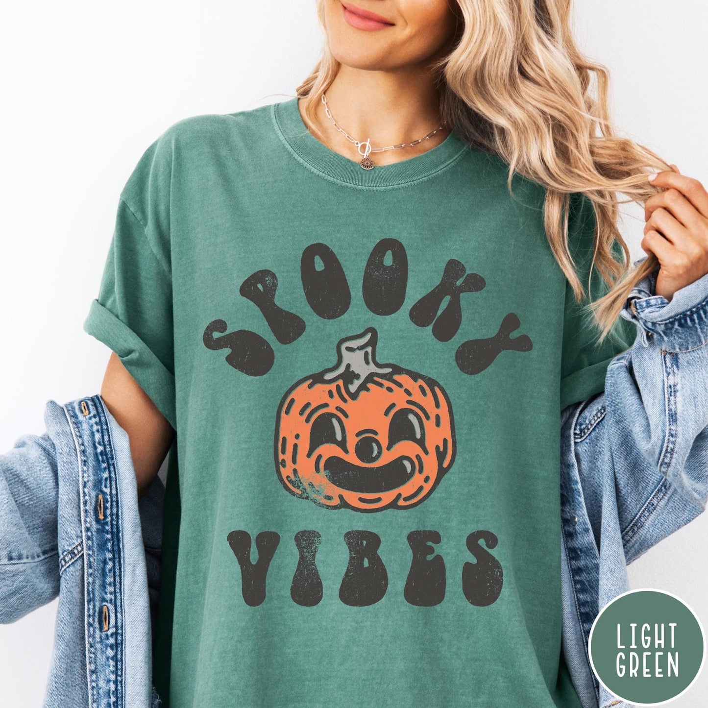 Comfort Colors tee in Light Green featuring retro style graphic with a smiling pumpkin and Spooky Vibes text