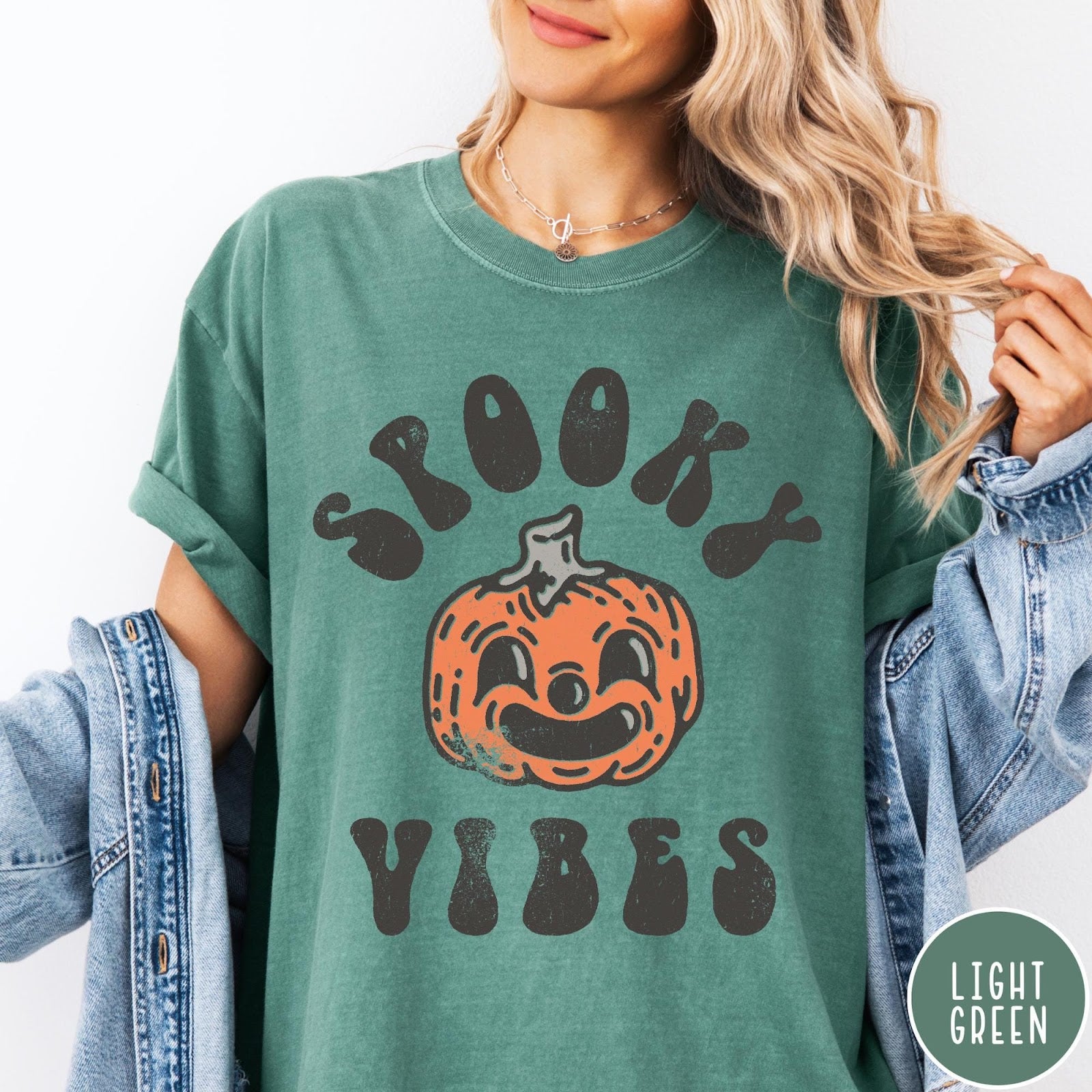 Comfort Colors tee in Light Green featuring retro style graphic with a smiling pumpkin and Spooky Vibes text