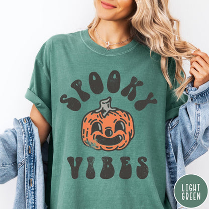 Comfort Colors tee in Light Green featuring retro style graphic with a smiling pumpkin and Spooky Vibes text